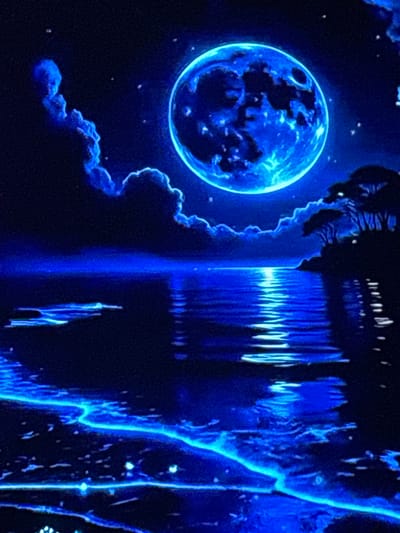 The image depicts a surreal, digitally rendered nighttime scene dominated by vibrant blues. A large, luminous full moon, rendered in shades of electric blue and white, hangs prominently in a star-speckled dark sky. Wispy, glowing blue clouds drift around the moon and across the upper portion of the image. Below, a dark body of water reflects the moonlight, creating a shimmering, elongated path of light. Along the right side of the water's edge, silhouetted trees with sparse foliage stand against the dark landscape, casting faint reflections on the water. The foreground shows a shoreline with glowing blue, ethereal lines that appear to be some form of bioluminescence or digital artistic effect. There are no people or recognizable landmarks of Skopje, North Macedonia, visible in this abstract, dreamlike composition.