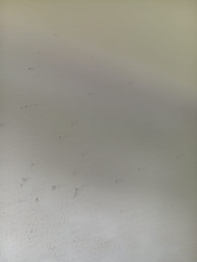 The image shows a close-up of a white or off-white wall with several dark spots or blemishes. The texture of the wall appears slightly rough. There are no people, subjects, objects, actions, or interactions visible. There is no location information about Domsühl, Germany in the image.