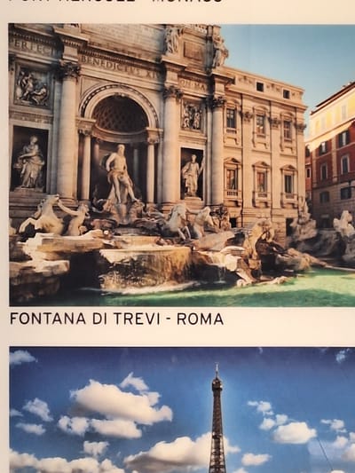 The image shows a postcard with two distinct halves. The top half features a photograph of the Trevi Fountain in Rome, Italy. The fountain is depicted with its intricate sculptures of Neptune, Tritons, and horses, set against the backdrop of baroque architecture. The text "FONTANA DI TREVI - ROMA" is printed below the image. The bottom half of the postcard displays a photograph of the Eiffel Tower in Paris, France, set against a bright blue sky with scattered clouds. There is no visible indication of the city of Bochum, Germany, or any related imagery in the provided photograph.