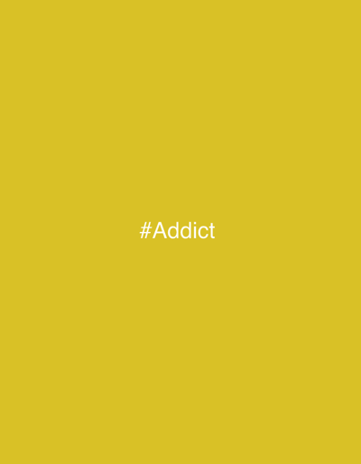 The image is a photograph of a solid yellow background. In the center of the image, the white text "#Addict" is displayed. There are no people, objects, or any discernible features of a city environment present.
