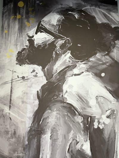 This is a black and white and sepia-toned ink drawing with subtle yellow accents, depicting a dynamic and abstract scene. The primary subject appears to be a person in motion, possibly dancing or engaged in a struggle. The figure is rendered in dark, bold strokes, creating a strong silhouette that dominates the left and central portions of the image. The body is contorted, with limbs appearing fluid and expressive, suggesting intense physical activity.
The background is a swirl of lighter grays and whites, with sharp lines and soft washes of ink that create a sense of depth and movement. Some areas are heavily textured, resembling rough brushstrokes or splatters, while others are smoother, creating a contrast that adds to the overall abstract quality. Scattered throughout the image are small, irregular splotches of bright yellow, which stand out against the monochrome palette and add a touch of vibrancy and intrigue. These yellow marks appear to be ink splatters, adding an element of spontaneity to the composition.
The overall impression is one of energy, power, and perhaps a touch of chaos. The depiction of the figure is not entirely literal, inviting the viewer to interpret the action and emotion. The lighting is dramatic, with strong contrasts between light and shadow, enhancing the sense of movement and form. There are no discernible objects or environmental cues that firmly establish a specific setting or time of day, beyond the abstract nature of the artwork itself. No visible text is present in the image.
