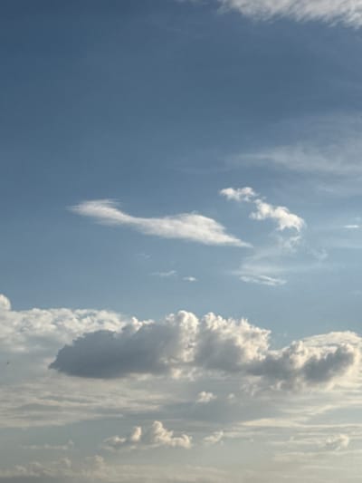 The image depicts a sky with scattered clouds, appearing to be taken from an elevated perspective, possibly a rooftop or a hilltop. The clouds are varied in size and texture, with some appearing thin and wispy, while others are more dense and puffy. The sky is a light blue, suggesting it is daytime, likely mid-morning or afternoon. There are no discernible landmarks or structures that would immediately place the scene within Abovyan, Armenia. The image is solely focused on the atmospheric conditions.