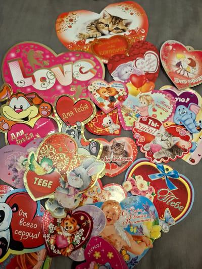 This image depicts a collection of Valentine's Day cards with various themes and designs, including images of cats, bears, a bunny, a cupid, and other cartoon characters. Many of the cards feature text in Russian, such as "Для тебя" (For you), "С Днем святого Валентина!" (Happy Valentine's Day!), and "Ты чудо!" (You are a miracle!). Some cards also have English text such as "LOVE". There is a reference to the city of Амзя, Russia.