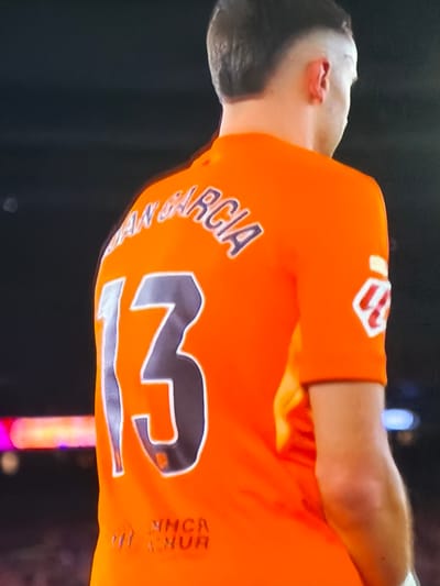 The image shows a person from the back wearing an orange jersey with the number 13 and the name "AN. GARCIA" on it. There is also a logo on the sleeve and writing at the bottom that reads "MHCR A.NUR". The location is suggested to be Sant Martí Sarroca, Spain.