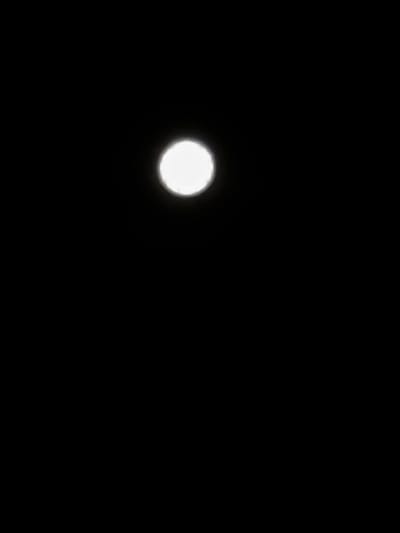 A luminous, off-center circular object is visible against a completely dark background. This object appears to be the moon, seen at night in Amarante, Portugal. The location in the city cannot be determined from the image.
