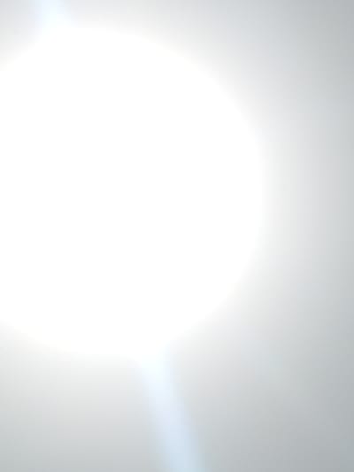 The image shows an out-of-focus, overexposed view, likely caused by direct sunlight or a strong light source aimed at the camera lens. The predominant color is white, with subtle gradations of gray suggesting a light-filled or reflective environment. No specific elements are discernible to provide location context related to Atani, Nigeria. No objects, actions, or people are visible.