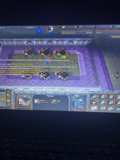 This is a screenshot of a video game, likely Warcraft III: Reign of Chaos, displayed on a computer monitor. The game is set in a fantasy environment with purple tiled ground and a stone structure in the foreground. Several in-game units, which appear to be mechanical spiders or similar creatures, are visible on the tiled area. The user interface of the game is present, showing text in Russian. This includes options like "Союзники" (Allies) and "Журнал" (Journal), and game-related information such as "Массовая Дуэль" (Mass Duel) and a timer indicating "00:11:59". There are also icons representing game resources and units. The image is taken from an angle, showing the computer screen and part of a keyboard below it. There is no indication of the city of Nikopol, Ukraine, in this image.