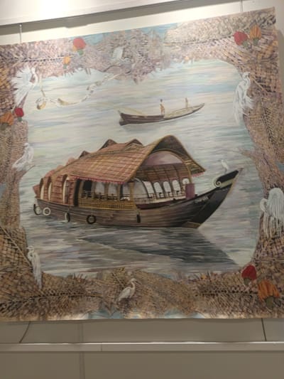 The image shows a painting depicting a backwater scene, likely in Kerala, India. The focal point is a large houseboat, with a thatched roof, and a smaller boat in the distance with two people on board. The scene is framed by a decorative border, possibly representing woven palm leaves, with white birds perched on it and red and orange fruits. The boat has a visible name "CHAMPARA" on its side. The water is calm, and the overall impression is serene and rural.
The painting does not depict Kasarvarne, India. Kasarvarne is a landlocked village, not located near the backwaters. This painting most likely represents Alleppey, India, or another coastal region in Kerala.