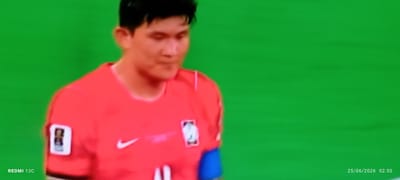 A male soccer player, wearing a red jersey with a white Nike logo and a badge on the left chest, is shown from the chest up. He has dark hair and is looking down. The background is a solid green, suggesting a sports field or a green screen. The bottom left corner of the image displays "REDMI 13C" and the bottom right corner shows "25/06/2026 02:50". There is no information available about this image being located in Idimu, Nigeria.