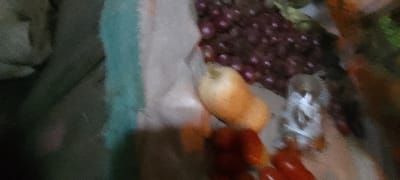 A cluster of red onions sits atop a tan butternut squash. Small, red tomatoes rest below, near a clear, disposable cup. These items are arranged on a muted background blending tones of tan, brown, and green. A hazy, semi-translucent effect obscures some details, adding a soft, diffused quality.