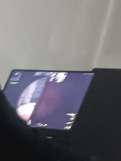 The image depicts a blurry screen showing gameplay of Counter-Strike: Global Offensive. The scene appears to be inside a building, with the player's view focused on a hallway. The game's interface is visible, including the HUD elements like player health, ammunition, and map information. The overall image quality is poor, likely due to the picture being taken of a screen instead of a direct screenshot. The monitor is black.