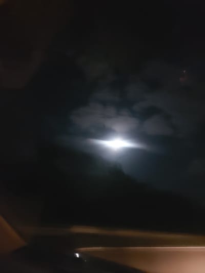 The image shows a dark, possibly nighttime, scene with a bright light source, likely the moon, obscured by clouds or fog. The overall impression is one of low visibility and atmospheric conditions. There are some vertical lines on the right side of the image. The location of Montemor-o-Velho, Portugal is not apparent from the visual elements.