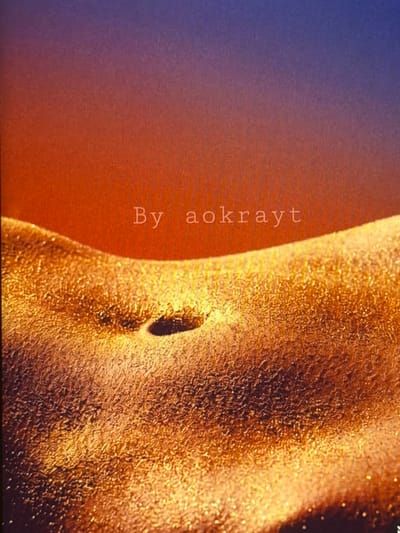 The image shows a close-up of a person's midsection, covered in a shimmering golden substance. A navel is visible in the center of the frame. The background transitions from a warm orange to a deep purple. The words "By aokrayt" are subtly overlaid on the image. There is no indication of a location in Bobrovo, Russia.