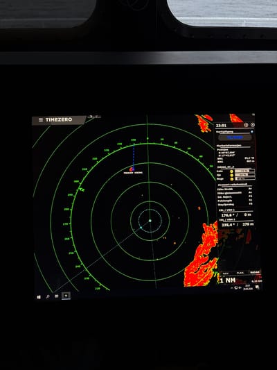 This image shows a close-up view of a marine radar display. The display shows a circular radar sweep with various icons and information panels. A prominent icon labeled "FREKOEY VIKING" is visible on the radar screen. The display indicates a current time of 23:51 and a date of 20.06.2026. On the right side of the screen, there is a panel with radar information including position coordinates (N 69°07.694', Ø 17°45.017'), gain settings, and other operational parameters. The radar is showing weather patterns or other significant targets in red and yellow hues. The context suggests this is likely the bridge of a vessel, possibly the "FREKOEY VIKING" itself, operating near the city of Espenes, Norway, given the geographic coordinates displayed. The overall environment is that of a vessel's navigation station.