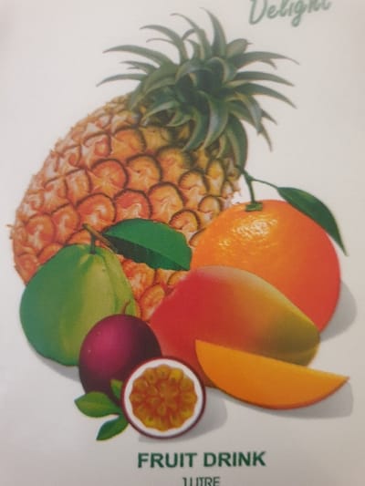 The image displays a brightly colored illustration of multiple fruits arranged on a plain white background, characteristic of a product label or advertisement. At the top left, a whole, ripe pineapple with a green crown is prominently featured. To its right, a whole orange with a small green leaf attached to its stem is visible. Below the pineapple, a round, smooth green fruit, possibly a guava or lime, is depicted. Centered lower in the composition are two passion fruits: one whole, dark purple, and another cut in half horizontally, exposing its orange pulp and numerous seeds. A whole mango, displaying a color gradient from green to yellow to red, is positioned behind the passion fruits and partially behind the orange. A single wedge of mango, uniformly orange-yellow, lies in front of the whole mango. Small green leaves are scattered among some of the fruits, notably near the green fruit and the whole passion fruit. Text elements are present: the word "Delight" in green cursive font is partially visible at the top right, and "FRUIT DRINK" in bold green sans-serif font is centered at the bottom, with "1 LITRE" partially visible beneath it. There are no people, actions, or interactions depicted. The illustration provides no visual information to determine a specific geographical location such as Mumbuni North ward, Kenya.