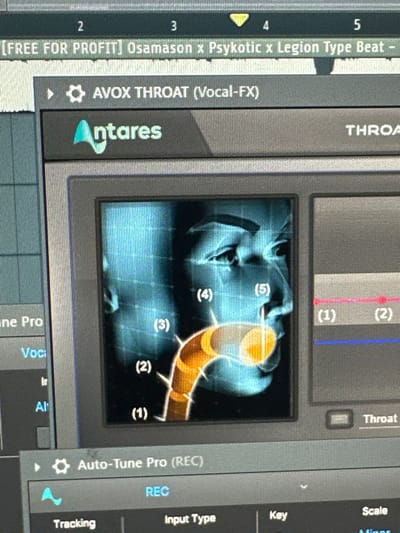 This image depicts a close-up of a computer monitor, located in Marcoussis, France. The screen displays a digital audio workstation (DAW) interface. At the top, a project title bar shows "[FREE FOR PROFIT] Osamason x PsyKotic x Legion Type Beat -". The primary focus is an active plugin window, identified by its title bar as "Antares AVOX THROAT (Vocal-FX)", featuring the "Antares" logo. Within this plugin, a stylized, blue-toned profile graphic of a human head, rendered with a grid overlay, is prominent. An exaggerated, glowing orange vocal tract is depicted within the head, segmented and numerically labeled (1) through (5) from the lower throat to the mouth and nasal cavity. To the right of this graphic, a user interface section contains horizontal parameter lines, labeled (1) and (2), with a control knob labeled "Throat" partially visible at the bottom. Below the AVOX THROAT plugin, a portion of another plugin, "Auto-Tune Pro (REC)", is visible, displaying a "REC" button and controls including "Tracking", "Input Type", "Key", "Scale", and "Minor".