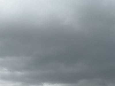 The image depicts a cloudy sky, with varying shades of gray indicating overcast conditions. There are no discernible objects, people, or actions visible in the frame. The scene is devoid of any specific landmarks or environmental features that would allow for pinpointing a location within Grapevine, Texas, United States of America. The focus is solely on the atmospheric conditions, characterized by dense cloud cover.