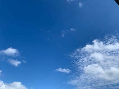 The image shows a bright blue sky with scattered white clouds. The clouds are of varying sizes and densities, with some appearing thin and wispy, while others are more voluminous and puffy. The overall impression is one of a clear and sunny day. There is no indication of any specific location within Volchansk, Russia, nor are there any people, subjects, objects, or actions depicted. The scene is purely an environmental landscape of the sky.