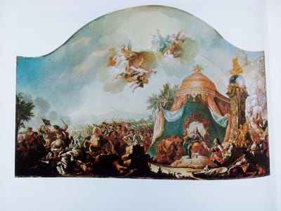 This painting depicts a grand, allegorical scene with a military battle on the left and a royal court on the right. In the sky above, putti and angelic figures are shown, suggesting divine intervention or triumph. The left side of the painting features a chaotic battle with soldiers on horseback and on foot, banners, and fallen figures. The right side shows a regal procession and a king seated on a throne under a canopy, with courtiers and attendants present. Elaborate architectural elements and ornate decorations are visible. The overall style is Baroque or Rococo, characterized by dramatic movement, rich colors, and a sense of grandeur. The painting is not located in the city of Zhmerynka, Ukraine; it is a historical painting whose specific location is unknown.