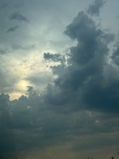 The media file is an image of a cloudy sky with the sun partially visible. The clouds are dark and ominous, suggesting stormy weather. The sun is a bright, diffused circle peeking through a gap in the clouds, casting a yellowish glow on the scene. The overall impression is one of dramatic and perhaps turbulent weather.
The scene is purely natural, focusing on the sky and its formations. There are no people or man-made objects clearly identifiable in the image itself. However, on the far right edge of the image, there are faint, vertical lines that could be interpreted as power lines or very distant structures, but they are not distinct enough to be certain.
The time of day is difficult to ascertain precisely due to the overcast conditions, but the presence of the sun suggests it is daytime. The weather appears to be partly stormy, with a mix of dark and brighter clouds. The location context provided is Brashlen, Bulgaria, but there are no specific visual cues within the image to confirm this location. The emotions evoked by the image could be a sense of awe at the power of nature, anticipation of a storm, or even a hint of melancholy due to the dark clouds.
There is no visible text in the image.