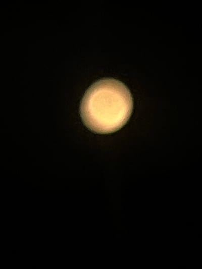 A blurry, off-center, yellow orb is set against a black background.