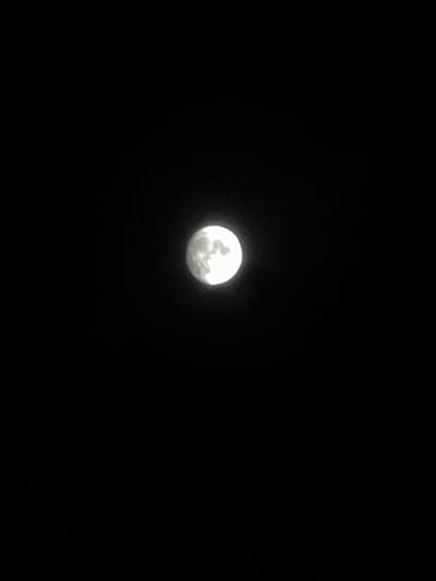 The image shows a full moon against a completely black sky. The moon is illuminated and appears bright white with visible surface features. The image does not provide any information about the city of Balkh, Tajikistan, or any other environmental or contextual details.