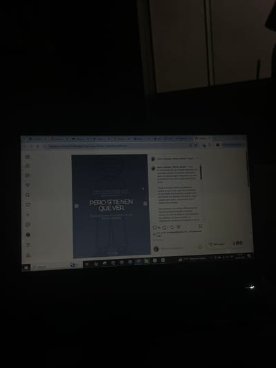 The image is a close-up, dimly lit shot of a laptop screen displaying an Instagram post. The post is from "rocio_mompo_clinica_dental" and discusses how dental issues can be linked to broader health concerns. The text mentions that a patient with bruxism may be grinding their teeth due to stress, poor sleep, or accumulated tension. It also states that inflamed gums can indicate problems beyond oral hygiene, suggesting a need to review habits, diet, and overall well-being. The post includes a graphic with Spanish text that translates to "We ask questions that, in principle, seem to have nothing to do with it. But they do have to do with it. Because the mouth does not function in isolation." A small portion of the surrounding environment is visible, showing a dark background that suggests the room is dimly lit. The lower part of the screen shows the Windows taskbar with icons for search, various applications, Wi-Fi, and the date and time, which is 07:19 on 30/05/2026. There is no indication of San Luis, Peru in the image.