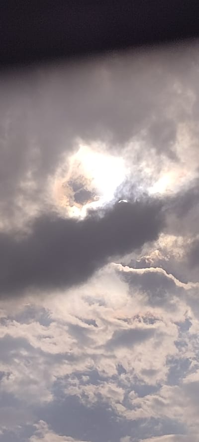 The image shows a cloudy sky in Matangpanyang, Indonesia. There is a bright area in the clouds, likely the sun shining through a gap. The clouds are various shades of grey and white. The overall scene suggests an overcast day.