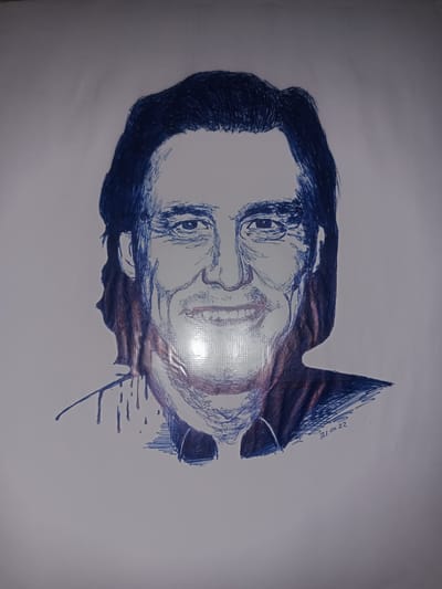 This is a portrait of a man, likely drawn with a blue ink pen. The man has dark hair, and is looking directly at the viewer with a wide smile. He appears to be wearing a collared shirt. The drawing is executed in a sketch-like style, with visible lines and shading. There are some reddish-brown accents on the drawing, particularly on the neck and shoulders. The background is plain white paper. In the lower right corner of the drawing, the date "31.01.22" is visible, indicating it was drawn on January 31, 2022. The image is illuminated by a bright light source, causing a significant glare in the center of the portrait, obscuring some of the details. The context provided suggests the location is Gulbag, Uzbekistan, however, there are no visual cues in the image itself to confirm this specific location. The mood conveyed by the portrait is cheerful due to the man's smile.