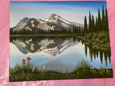 This is a painting of a serene mountain landscape. The scene depicts snow-capped mountains reflected in a calm lake. In the foreground, lush green grass and wildflowers add a touch of color. Pine trees line the shore of the lake, creating a sense of depth and scale. The sky is a clear, bright blue, suggesting a beautiful day. The overall mood is peaceful and tranquil, inviting the viewer to appreciate the natural beauty of the scene. There is no visible text in the image. The location context provided is Luh, Ukraine, but there are no specific visual cues in the painting to confirm this location.