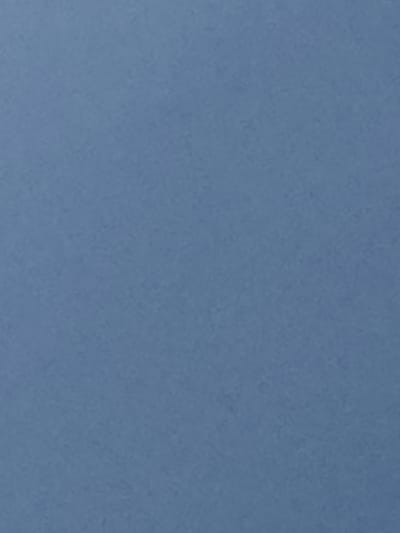 This media file is a cropped image showing a textured, solid blue surface. There are no discernible subjects, objects, activities, or events taking place. The image is abstract and lacks any specific details regarding time of day, weather, location cues, or emotions. No text is visible in the image.