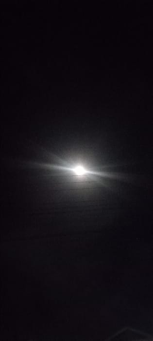 The image shows a night sky with the moon shining brightly in the center, illuminating the clouds. The coordinates (-0.541, 37.441) correspond to a location in Kanjuu, Kenya, but the image does not show any identifiable features of the city or landscape.