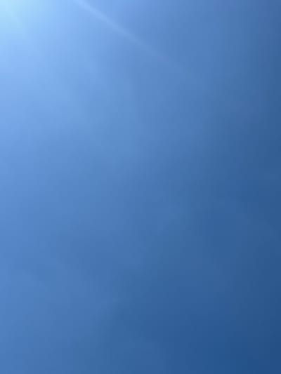 The image shows a clear blue sky with a faint diagonal streak of light, possibly from the sun partially obscured or a lens flare effect, in the upper left quadrant. The sky is the dominant feature, with no visible clouds or other elements. The image's context suggests it was taken outdoors in the Драчкаўскі сельскі Савет, Belarus, but there are no discernible man-made structures or natural landscapes to confirm a specific location within that area.