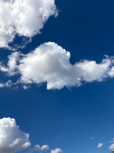 The image shows a bright blue sky with scattered white clouds. The clouds are fluffy and appear to be cumulus clouds. There are no people, buildings, or any other objects visible in the image. The scene is a clear and sunny day. The location is not identifiable from the image itself, but it is described as Solone, Ukraine.