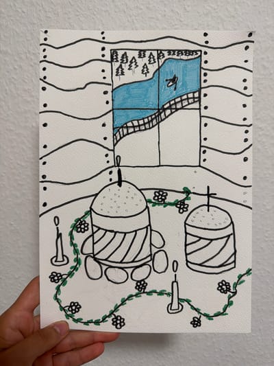 The image is a drawing on textured white paper, depicting a scene with a window overlooking a landscape and objects in the foreground. The drawing is done in black ink with some blue and green coloring.

In the background, through a rectangular window, a blue body of water is visible, with trees lining the bank. A bridge crosses the water, and a dark, abstract shape is in the water.

In the foreground, two dome-shaped objects with striped sides and dotted tops are positioned centrally. One is larger than the other. Three lit candles are present: one to the left of the larger dome, one to the right, and one between the two domes. A green vine with small black flowers winds around the domes and the candles. Several oval shapes, possibly stones, are placed around the base of the larger dome. The edges of the drawing are bordered by black dots along wavy black lines.

The drawing is held by a person's hand on the lower left side, with a portion of their thumb visible.

The image does not contain any specific landmarks or elements that would allow it to be identified as being located in Nienburg/Weser, Germany.