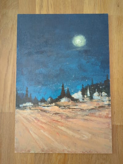 The image is a painting of a night landscape with a moon in the sky. The moon is a bright, pale yellow orb, slightly diffused by clouds. The sky is a deep, dark blue, with lighter blue streaks suggesting atmospheric texture. In the middle ground, there is a silhouette of buildings or structures that appear to be illuminated from within, with white and light grey accents. These structures are clustered together and have pointed roofs or spires, resembling a village or a collection of minarets. Darker, vertical shapes, possibly trees, are interspersed among the buildings. The foreground depicts a sandy or dusty terrain with diagonal brushstrokes of orange, peach, and white, creating a sense of movement or a path. The overall impression is a serene, possibly mystical, night scene. The location in Taucha, Germany, is not visually depicted or suggested by the painting itself.
