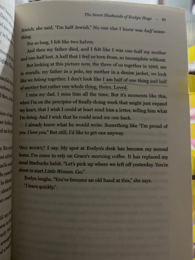 An open paperback book, identified as 'The Seven Husbands of Evelyn Hugo' on page 91, is presented. The right page displays black printed text on white paper, featuring narrative and dialogue. Two distinct text segments are faintly underlined: 'one whole thing, theirs. Loved.' and 'I miss my dad. I miss him all the time.' A yellow rectangular page marker is visible along the right vertical edge of the right page. The background is blurred and indistinct. No individuals or specific actions are visually depicted. This scene is located in Irapuato, Mexico.
