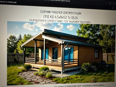 The image displays a screenshot of a digital document on a computer screen. The document title appears to be "8x52 1s 0626.pdf". Below this, in Russian text, are several lines of headings and subheadings. The main heading reads "СБОРНИК РАБОЧЕЙ ДОКУМЕНТАЦИИ" (Collection of Working Documentation). Beneath this, it states "СРД КД 6,5х8х52 1з 0626" (SRD KD 6.5x8x52 1s 0626). The following line reads "РАЗРАБОТАНО В СООТВЕТСТВИИ С ТЕХ. ЗАДАНИЕМ ЗАКАЗЧИКА" (Developed in accordance with the technical specification of the customer).
The lower part of the screenshot features a photograph of a small, modern wooden house with a covered porch. The house has a pitched roof, large windows with blue curtains, and wooden siding. The porch is supported by dark posts and has a wooden railing. In front of the house, there is a stone pathway leading through a grassy yard with bushes and small white flowers. A wooden fence is visible in the background, as well as trees and a clear sky with some clouds. There is no indication of the city of Демихово, Russia, or any people in the image.