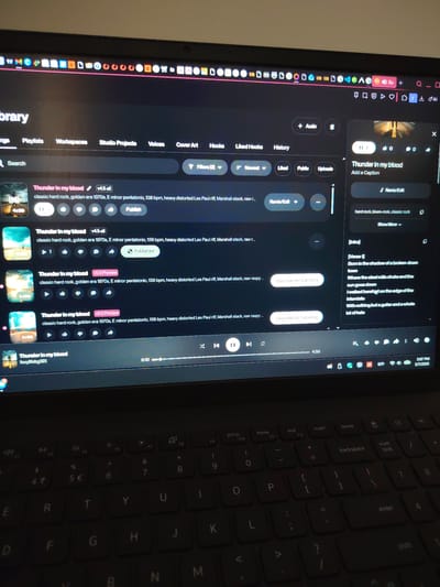 A person is interacting with a laptop. The laptop screen shows a music production or sharing platform with a song titled "Thunder in my blood". Multiple versions of the song are visible, with options like "Publish" and "Upgrade for full song". The right side of the screen displays song details, lyrics, and playback controls. The keyboard is visible, with a standard QWERTY layout and function keys. The taskbar shows icons for various applications and the system clock displaying 5:07 PM on 5/7/2026. No information indicates the city of Georgenberg, Austria.