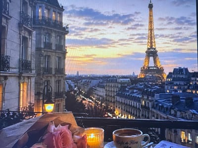 This media file depicts a romantic balcony view of Paris at dusk. The Eiffel Tower is prominently featured in the distance, illuminated by a warm glow. The sky is a blend of soft blues, purples, and oranges, indicating either sunrise or sunset. In the foreground, a balcony railing is visible, with a candle casting a warm light and a cup of coffee with the text "Cafe de Flore" on it. A bouquet of pink roses adds a touch of elegance to the scene. The buildings in the cityscape are classic Parisian architecture with mansard roofs and lit windows, suggesting the city is coming alive with evening activity. The overall mood is peaceful, romantic, and serene. This scene is not in Kuvshinovo, Russia, but rather Paris, France, based on the iconic Eiffel Tower and Parisian architecture.
