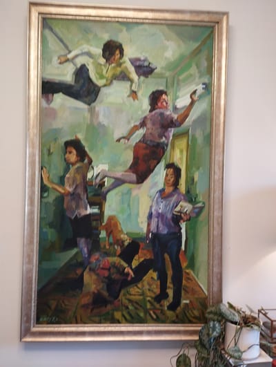 The painting depicts an indoor scene with multiple figures and a dog, rendered in a loose, impressionistic style with a dominant palette of greens, blues, and earth tones. In the upper portion of the painting, two figures appear to be floating or jumping in mid-air. One, dressed in a light green shirt and dark pants, is in a dynamic pose, reaching out. Another figure in a purple shirt and red skirt is also airborne, with an outstretched arm.
Below them, a woman in a light purple shirt and dark pants stands on the right, holding an open book. To her left, a woman in a greyish-purple shirt and black shorts is positioned mid-body, with her hand raised as if touching a wall or surface. A small, light brown dog is visible between the standing woman and the figure in greyish-purple. In the lower foreground, a figure in a brown and green patterned garment is lying down, possibly interacting with the dog. The setting appears to be a room with green walls and a patterned floor, suggesting an interior space. There is no clear indication of time of day or weather, and the emotions are difficult to discern due to the abstract style. A signature is faintly visible in the lower left corner of the painting.