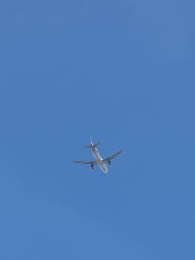 A passenger airplane is flying in a clear blue sky. It is daytime. There is no indication in the image to ascertain whether this image was taken in Oberhausbergen, France.