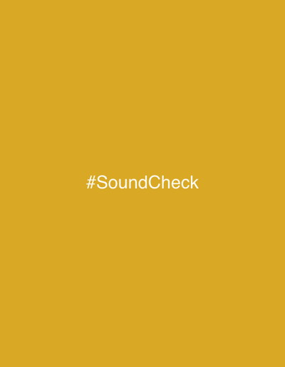 A solid yellow-gold background dominates the image. Centered horizontally and vertically, the text "#SoundCheck" is displayed in a simple, sans-serif font. The text is white, providing contrast against the dark yellow background. The image conveys a simple, minimalistic aesthetic, drawing attention to the hashtag rather than intricate visual elements.