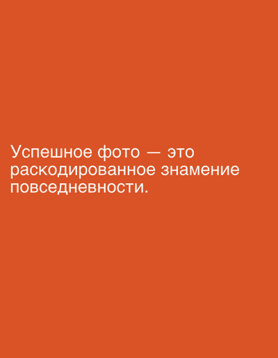 The image shows a plain, bright orange background. In the center of the image, white text in Russian is displayed. The text reads: "Успешное фото — это раскодированное знамение повседневности." This translates to "A successful photo is a decoded sign of everyday life." There are no people, objects, or environmental details visible in the image. The image does not contain any information related to the city of Even Yehuda, Israel.