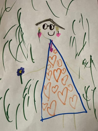 The image depicts a child's drawing on white paper, showing a figure with a triangular, heart-patterned dress in a grassy or floral environment. The figure has a head with visible eyes, nose, and mouth, with pink circles for cheeks. The triangular dress is outlined in blue and filled with orange heart shapes. Green lines are scattered around the figure, representing grass or foliage. A blue flower with a yellow center is present near the bottom of the drawing. The environment seems outdoors. There is no information related to the city of Granovshchina, Russia.