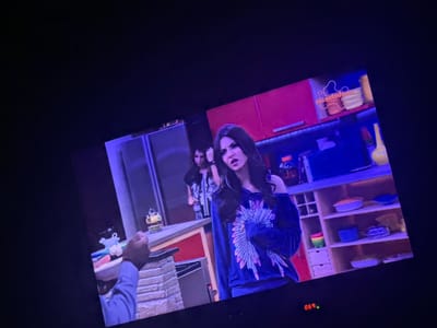A television screen is showing a scene from a Nickelodeon television show. A female character is in focus, wearing a dark jacket with a floral design on the back. In the background, there is a brightly colored kitchen set with shelving containing various objects. The Nickelodeon logo is visible at the bottom of the screen. A red digital number '690' is in the top left corner. The location is inside a home, likely in Rakovski, Bulgaria.