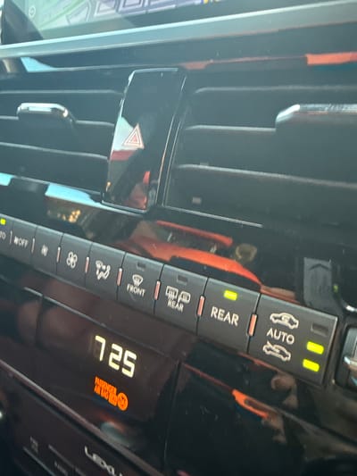 The image shows the interior of a Lexus vehicle, specifically the climate control panel. The "AUTO" function is active for both front seats and the rear climate control is also activated. The display shows "7:25" with a warning light indicating a possible issue with the passenger airbag system. The vehicle is likely located in Plantation, United States of America based on the request.