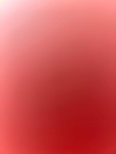 The image is a plain, out-of-focus background that transitions from a light pinkish-white hue in the top left corner to a deep red in the bottom right corner. There are no discernible subjects, objects, actions, interactions, or environmental details visible in the image. The location in Belidzhi, Russia is not depicted.