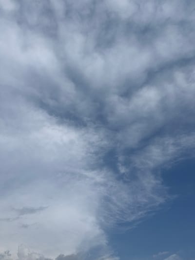 The image depicts a daytime sky with varied cloud cover. The upper right corner shows a section of clear, blue sky. The majority of the image is filled with layered white and gray clouds. No people, subjects, or objects other than the sky and clouds are visible. There is no information about the location of the image within Sanctorum, Mexico.