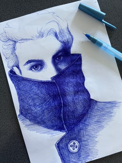 This is a close-up, overhead shot of a ballpoint pen drawing on white paper. The drawing depicts a person's face from the eyes down, with their face partially obscured by a high collar or scarf. The person has light-colored hair with stylized waves. The drawing is done entirely in blue ink, with cross-hatching used to create shading and texture on the collar and clothing. A single blue pen and its cap are placed on the paper to the right of the drawing. The paper is situated on a dark, textured surface, which could be a table or countertop. There is no indication of a specific city or location like Rezina, Moldova.